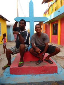 Dionis Cordales (izquierda) y su hermano Guillermo conversan bajo la cruz pintada de azul, el monumento más importante de Santa Cruz del Islote. Foto: Juan Uribe